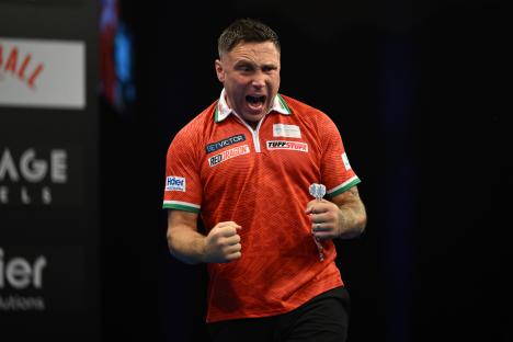 Gerwyn Price of Wales celebrates at a darts match.