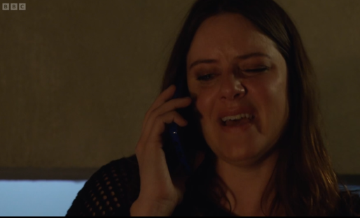Screenshot of a woman crying while talking on a cell phone.