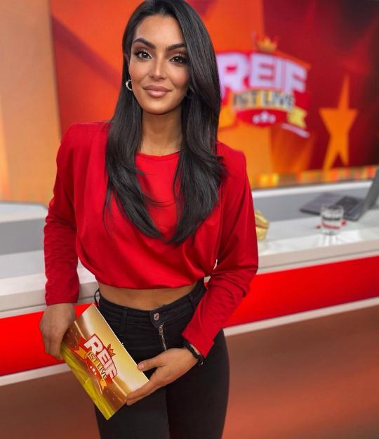 Woman in red shirt holding a show program.
