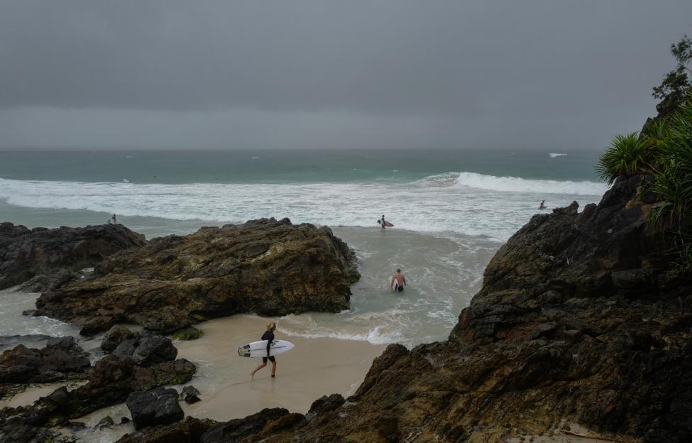 Surfers in Byron Bay, Australia during a rainstorm.