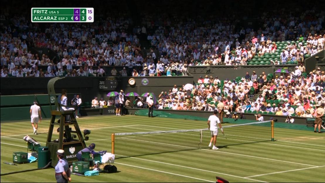 Wimbledon tennis match suspended; Taylor Fritz assisting a spectator.