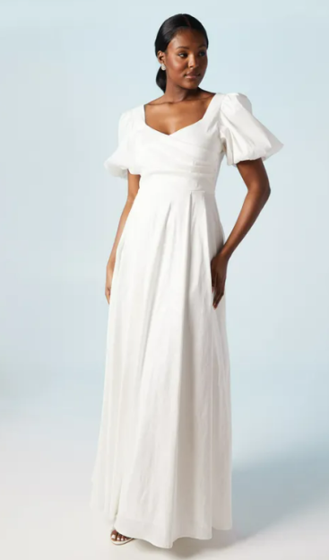 Woman in a white maxi dress with puff sleeves.