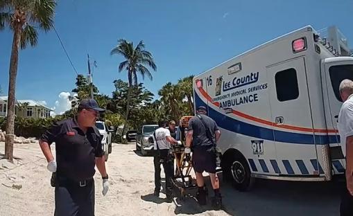 Emergency responders loading a stretcher into an ambulance.