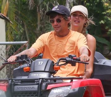 Louis Tomlinson and Zara McDermott riding an ATV.