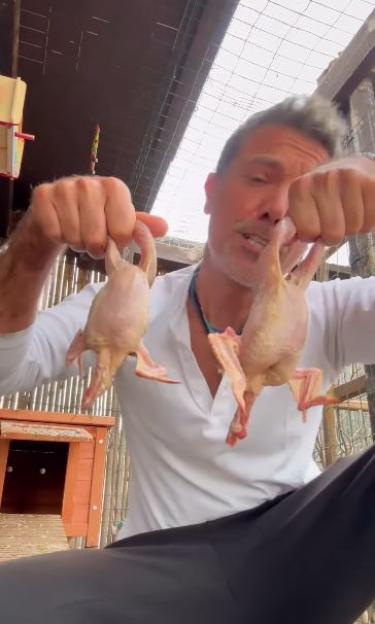 Man holding two raw birds.