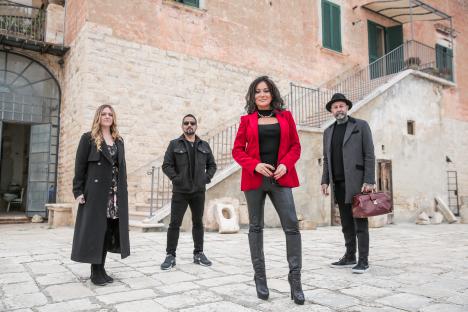 Nancy Dell'Olio and three other people standing outside an old building.