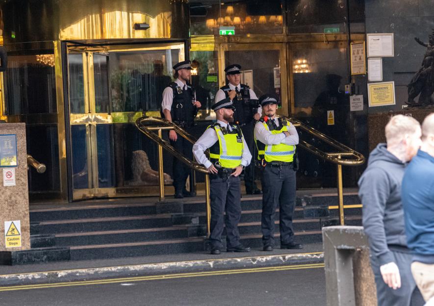 Police officers outside a hotel during a protest.
