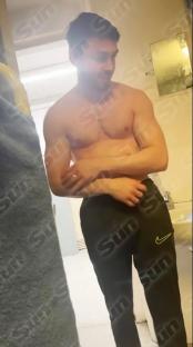 Arthur Collins, shirtless, putting on sweatpants in a prison bathroom.