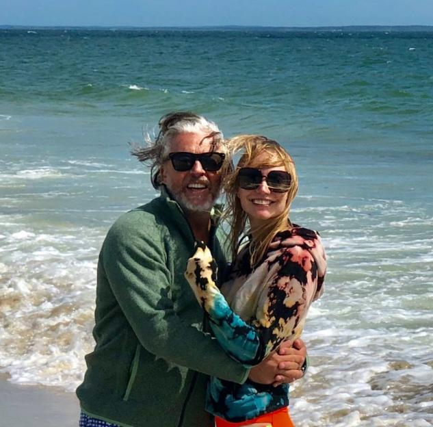 Roland Orzabal and his wife, Emily Rath Orzabal, embracing on a beach.