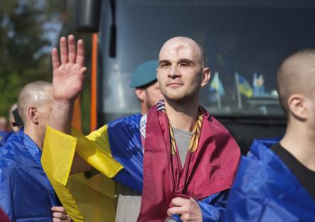 A Ukrainian prisoner of war waves as he is released during a prisoner exchange.