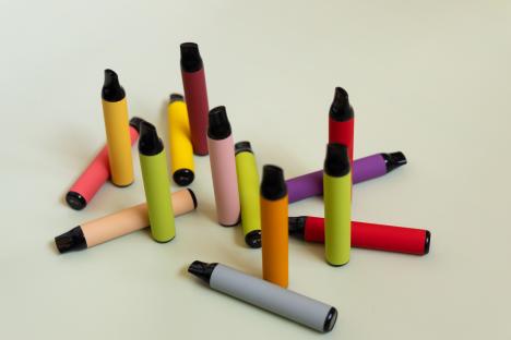 A collection of colorful disposable e-cigarettes.
