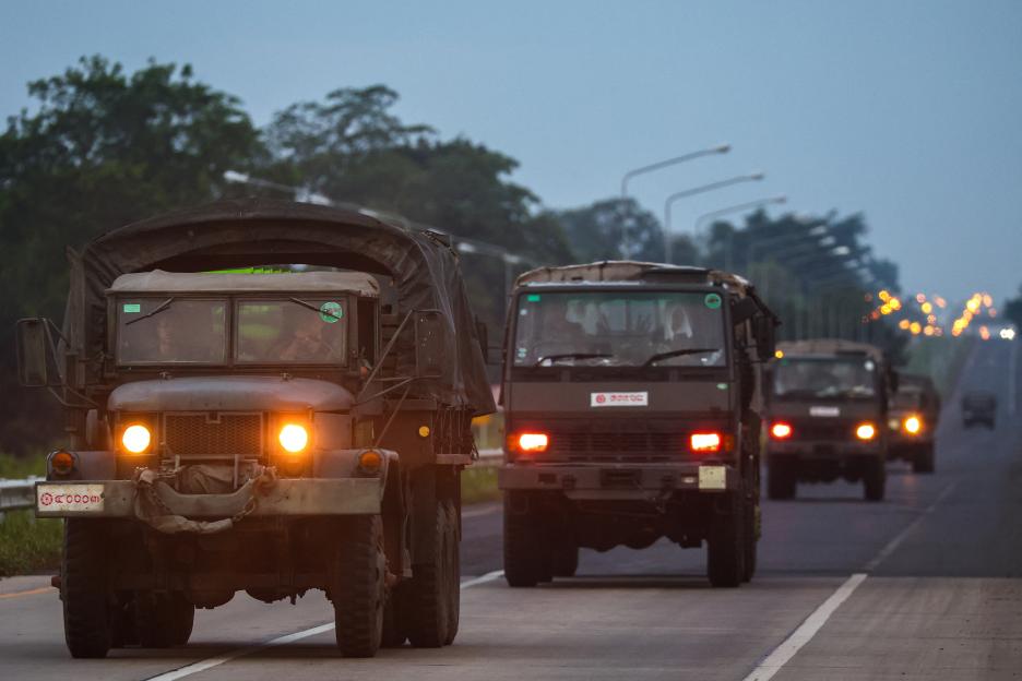 Military vehicles driving on a road.