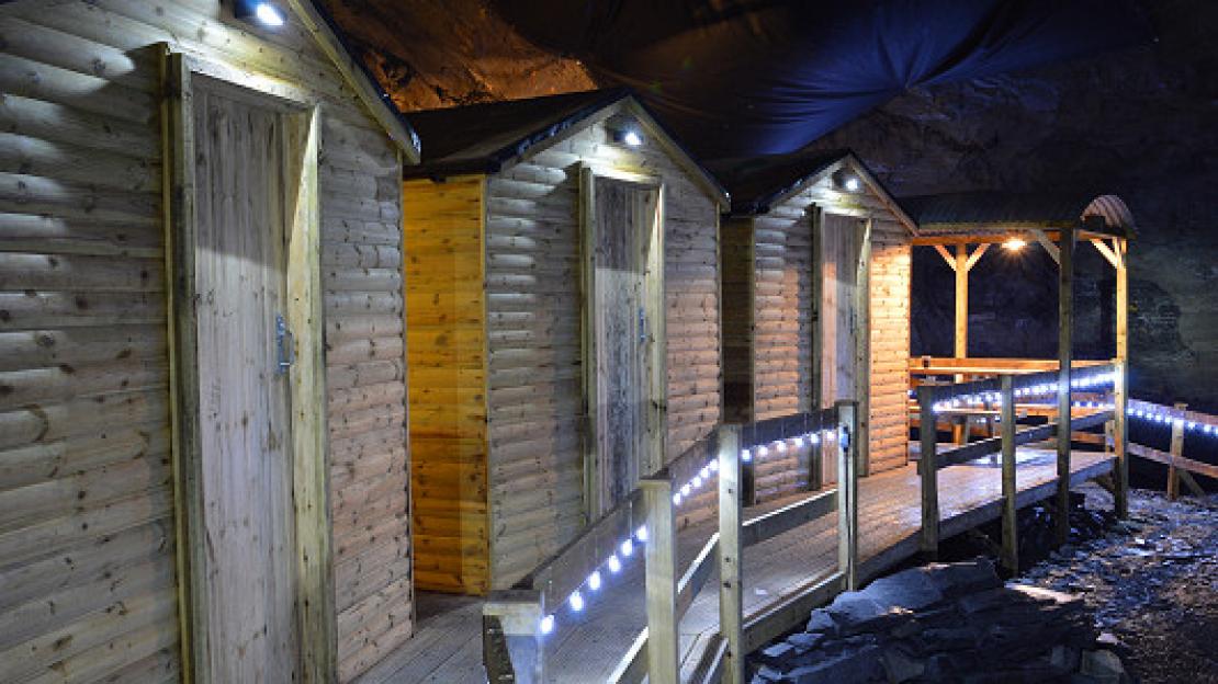 Wooden cabins lit at night in a mine.