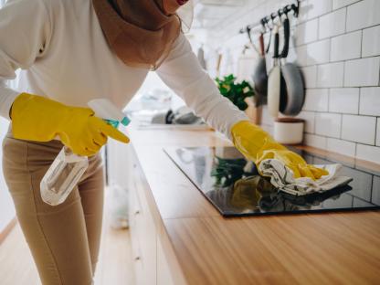 Person washing a burnt pot in a sink.