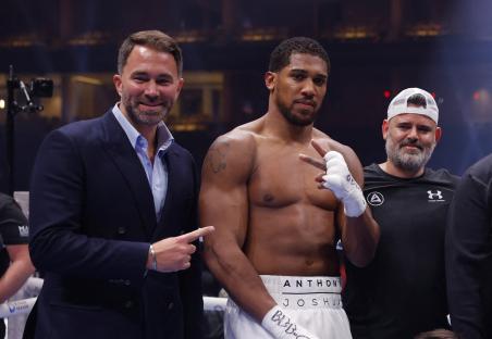 Anthony Joshua posing with his promoter after a boxing match.