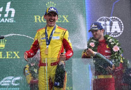 Robert Kubica celebrating a win at Le Mans, spraying champagne.