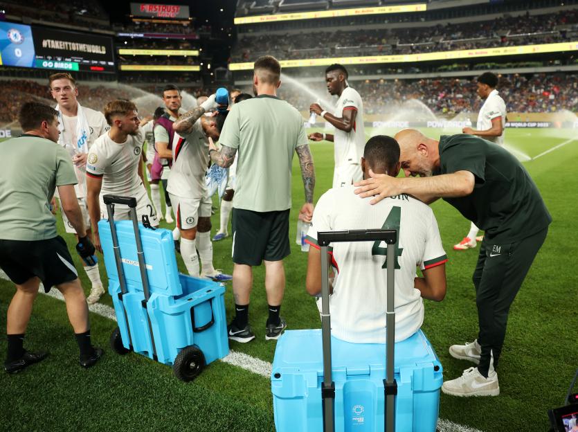 Soccer player receiving attention from coach during a hydration break.