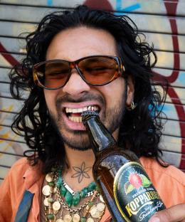 Man using his teeth to open a bottle.