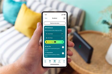 Person holding phone showing WiFi enhancer settings.