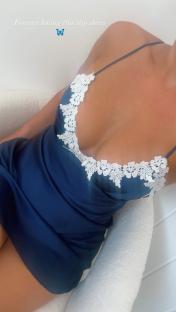 Woman in a blue slip dress with white lace trim.