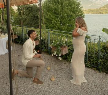 Man proposing to a pregnant woman outdoors.