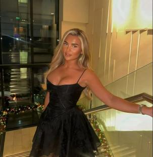 Woman in black dress on staircase.