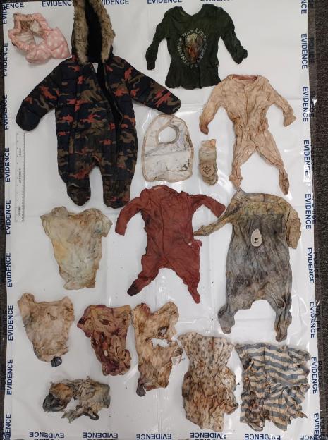 Baby clothing items presented as evidence.