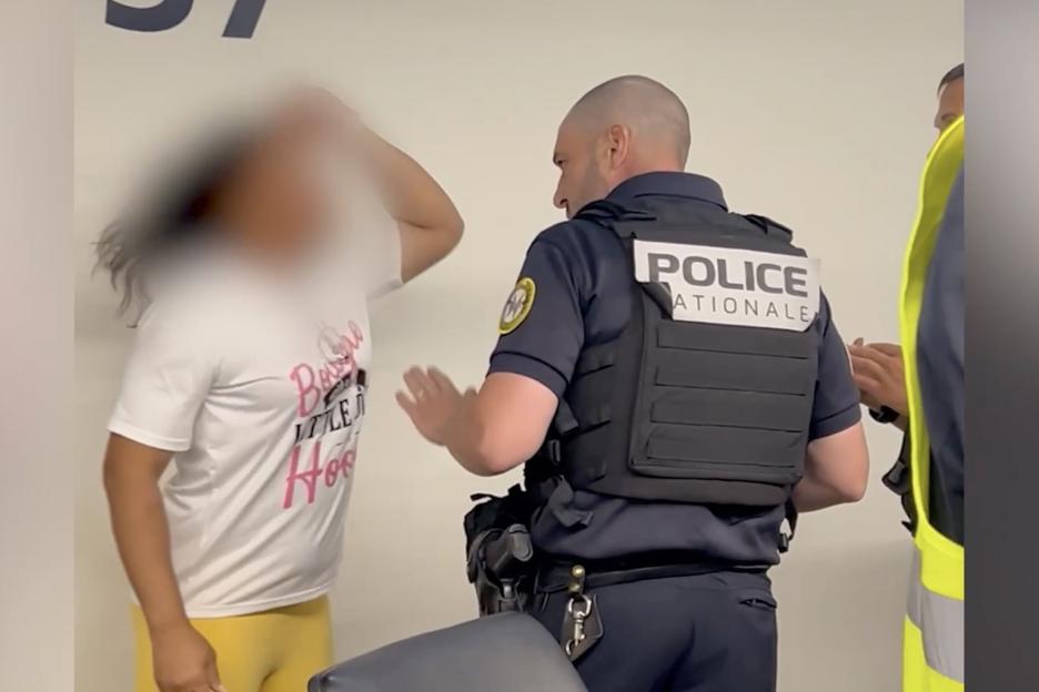 A police officer calming down an angry passenger at an airport.