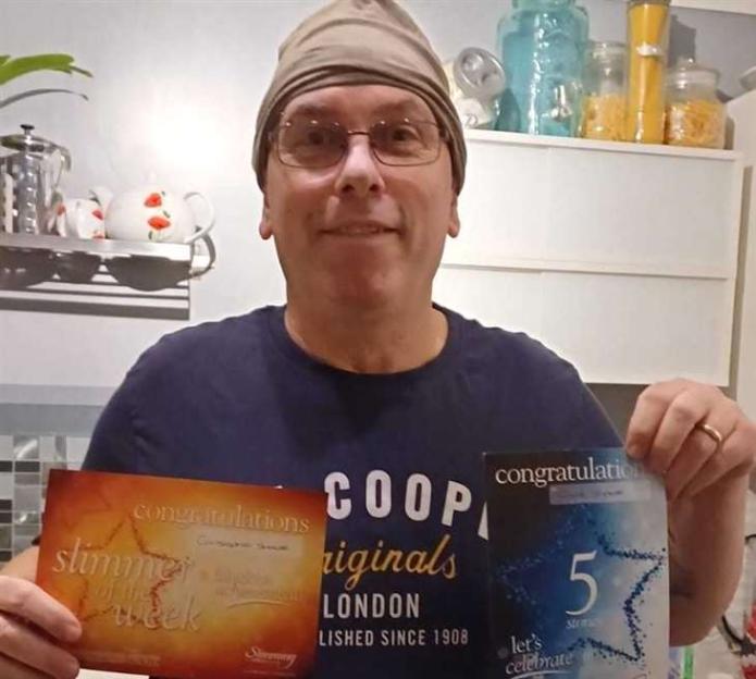 Man holding two award certificates.