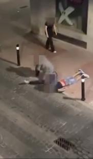 A person being choked on the ground by another person at night.