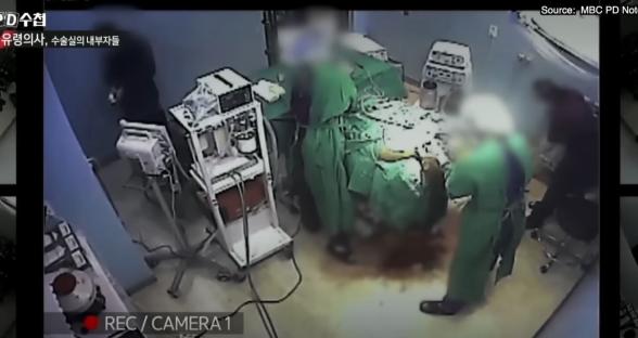 Surveillance footage of a surgical room with a large amount of blood on the floor.