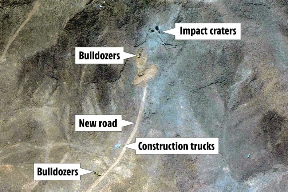 Aerial view of construction site showing bulldozers, construction trucks, a new road, and impact craters.
