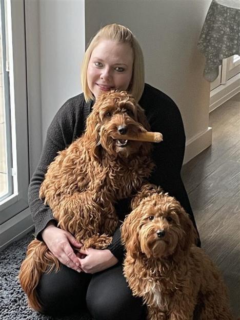 Woman sitting with two brown dogs.