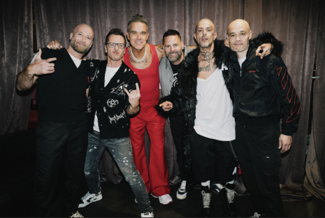 Robbie Williams and the band Five posing together.