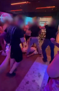 Person on the ground surrounded by a crowd of people.