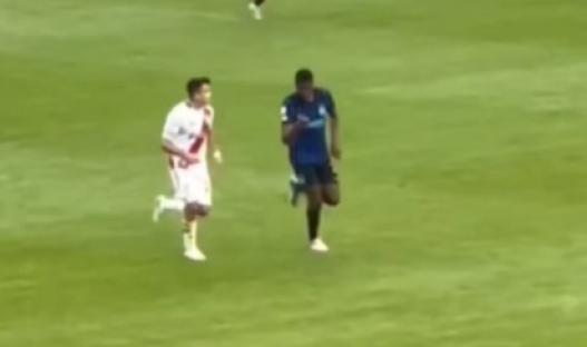Two soccer players running on a field.