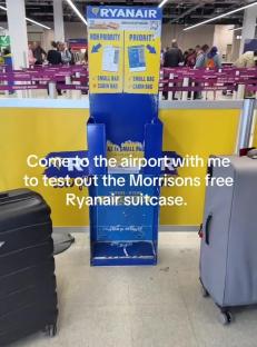 Ryanair baggage size information stand with two suitcases.