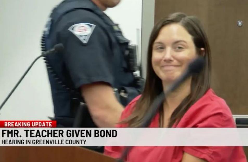 A former teacher smiles in court after being released on bail.