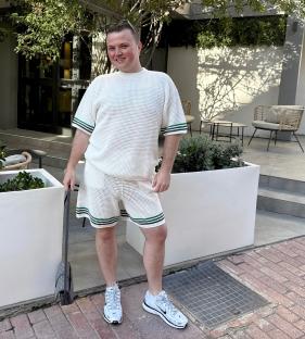Man in white knit shorts and shirt set.