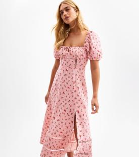 Woman in pink floral puff-sleeve midi dress.