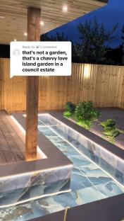 Nighttime view of a modern garden with a water feature and a comment calling it a