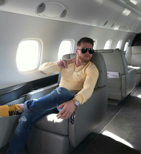 Man in sunglasses sitting in a private jet.