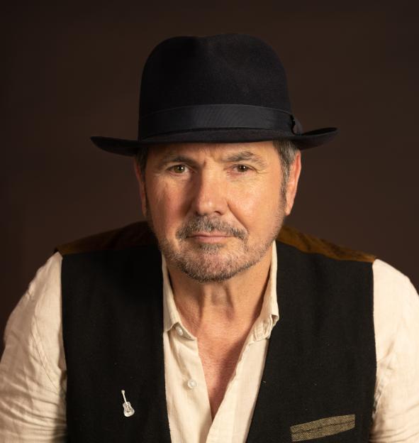 Alan Fletcher wearing a hat and vest.