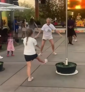 Woman and girl dancing outdoors.