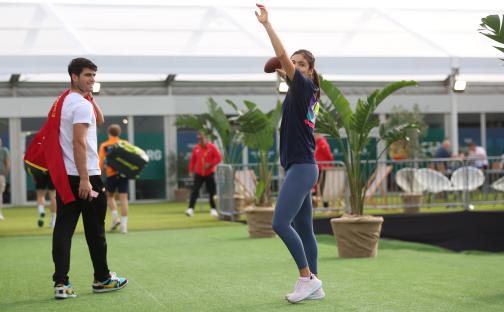 Emma Raducanu warming up with a football, Carlos Alcaraz watching.