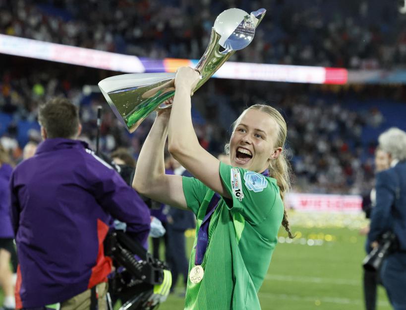Hannah Hampton holding the UEFA Women's EURO trophy.