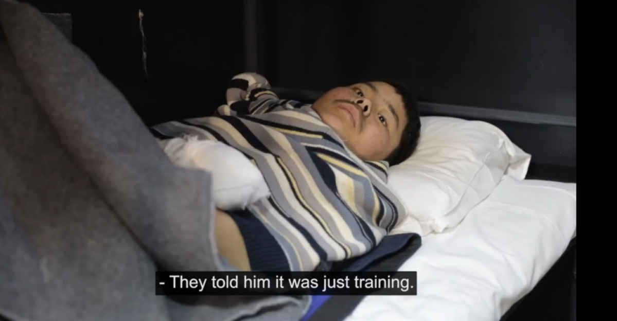 Man lying in bed, bandaged hand.