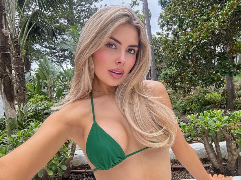Woman in green bikini in tropical setting.