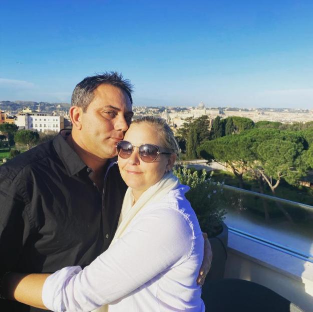Couple embracing with Rome in the background.