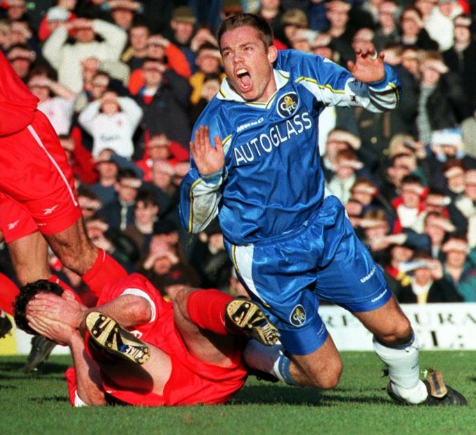 Photo of Robbie Fowler on the ground after a tackle during a soccer match.